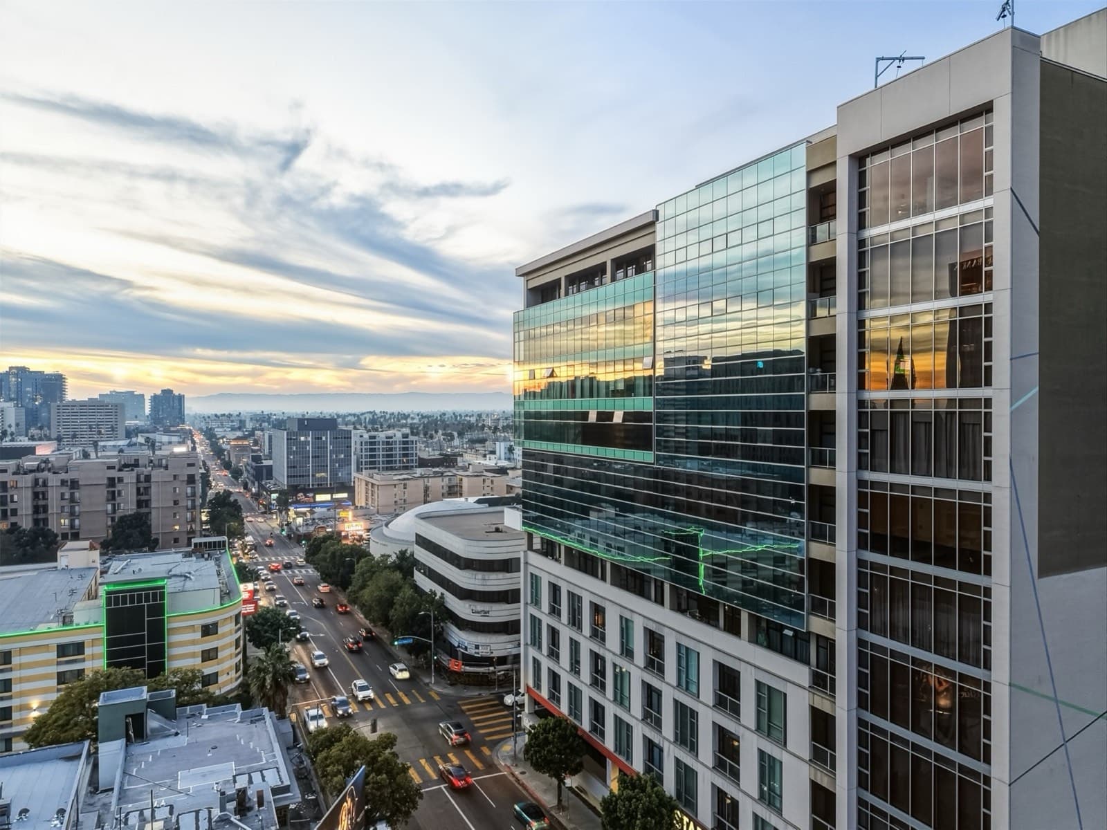 Golden-hour aerial view over a Koreatown boulevard toward the high-rise at 3223 W 6th St