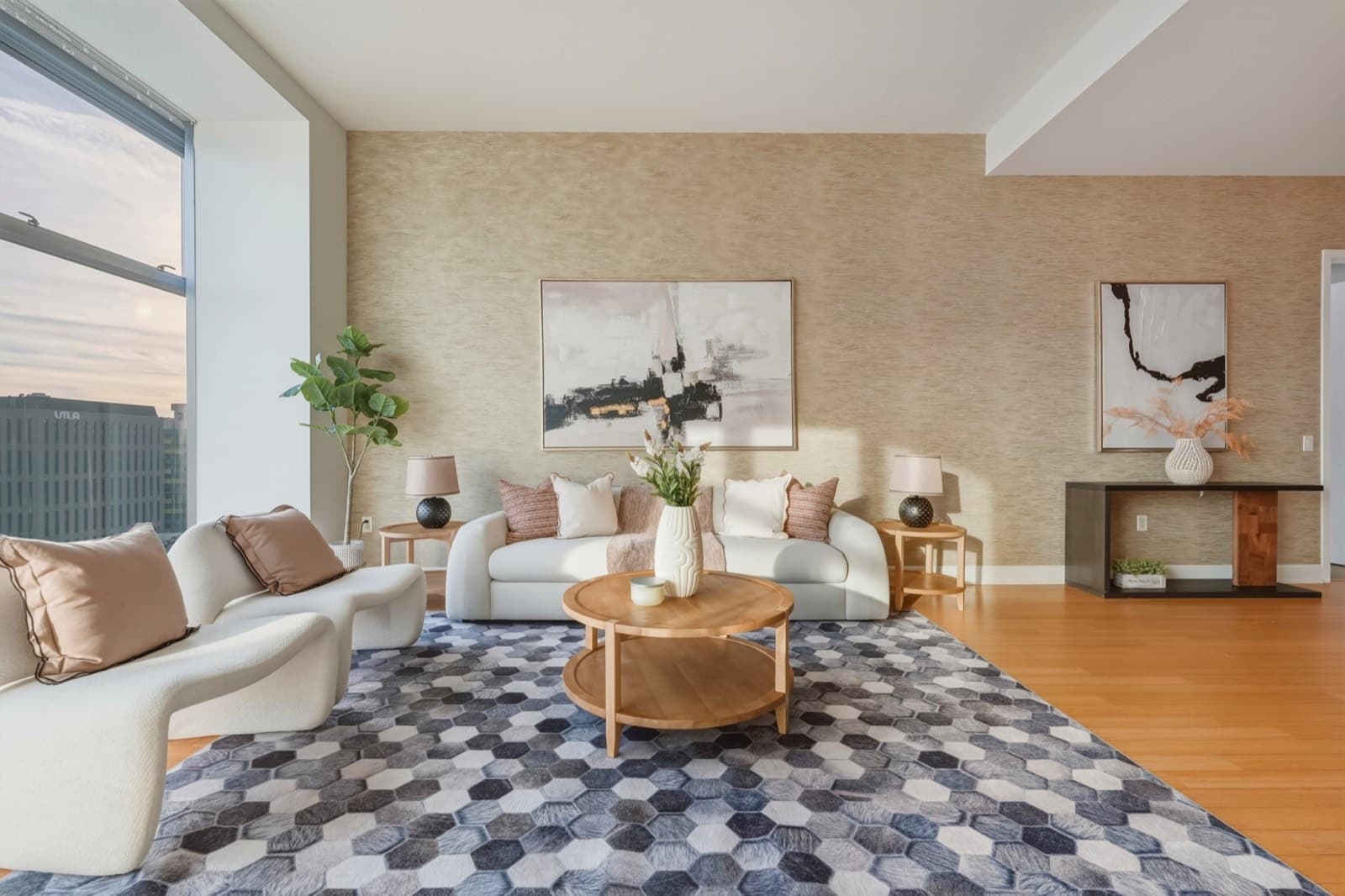 Staged living room with a skyline view through floor-to-ceiling windows in the Koreatown unit